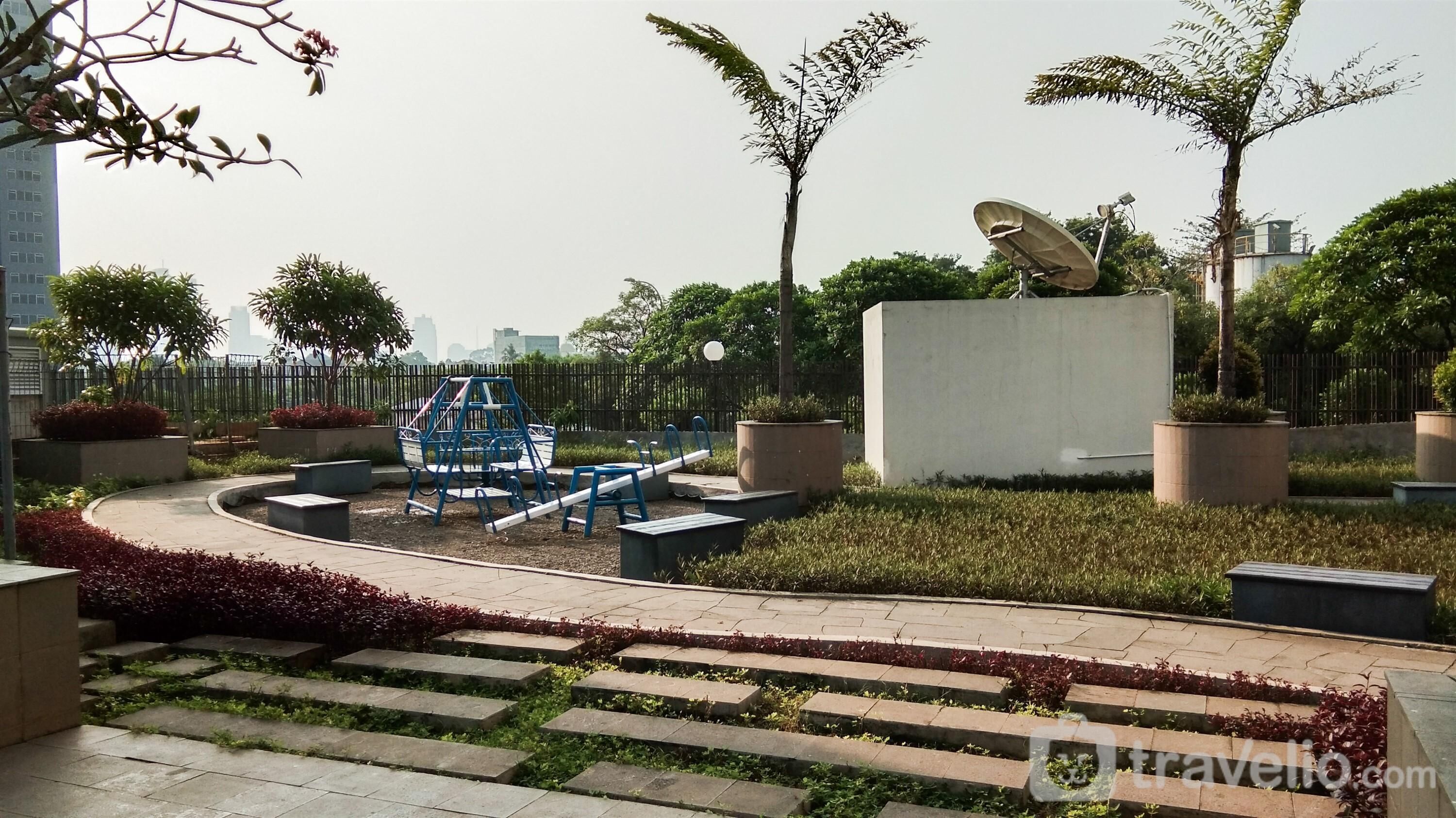 Ein Park mit Spielgeräten, einer Satellitenschüssel und einer Betonmauer.