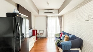A compact living space with a kitchenette, a sofa, and a dining area. - Cozy 1Br Apartment At The Wave Kuningan (Jakarta)