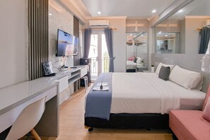 A modern hotel room with a bed, desk, and TV. - Modern Chic Studio At Sky View Apartment (South Tangerang)