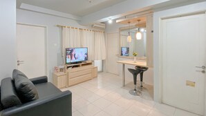 Een moderne woonkamer met een televisie, een bank, een eettafel en een spiegel.