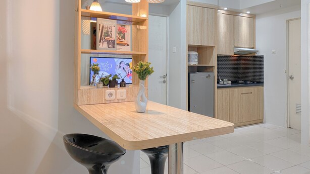 Een moderne keuken met houten kastjes, een ingebouwde oven en een zwarte betegelde spatwand.