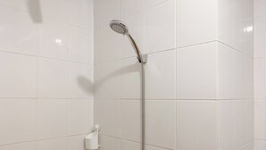A shower with a handheld showerhead and a wall-mounted faucet. - Compact 2Br Apartment Direct Access To Mall At Green Pramuka City (Jakarta)