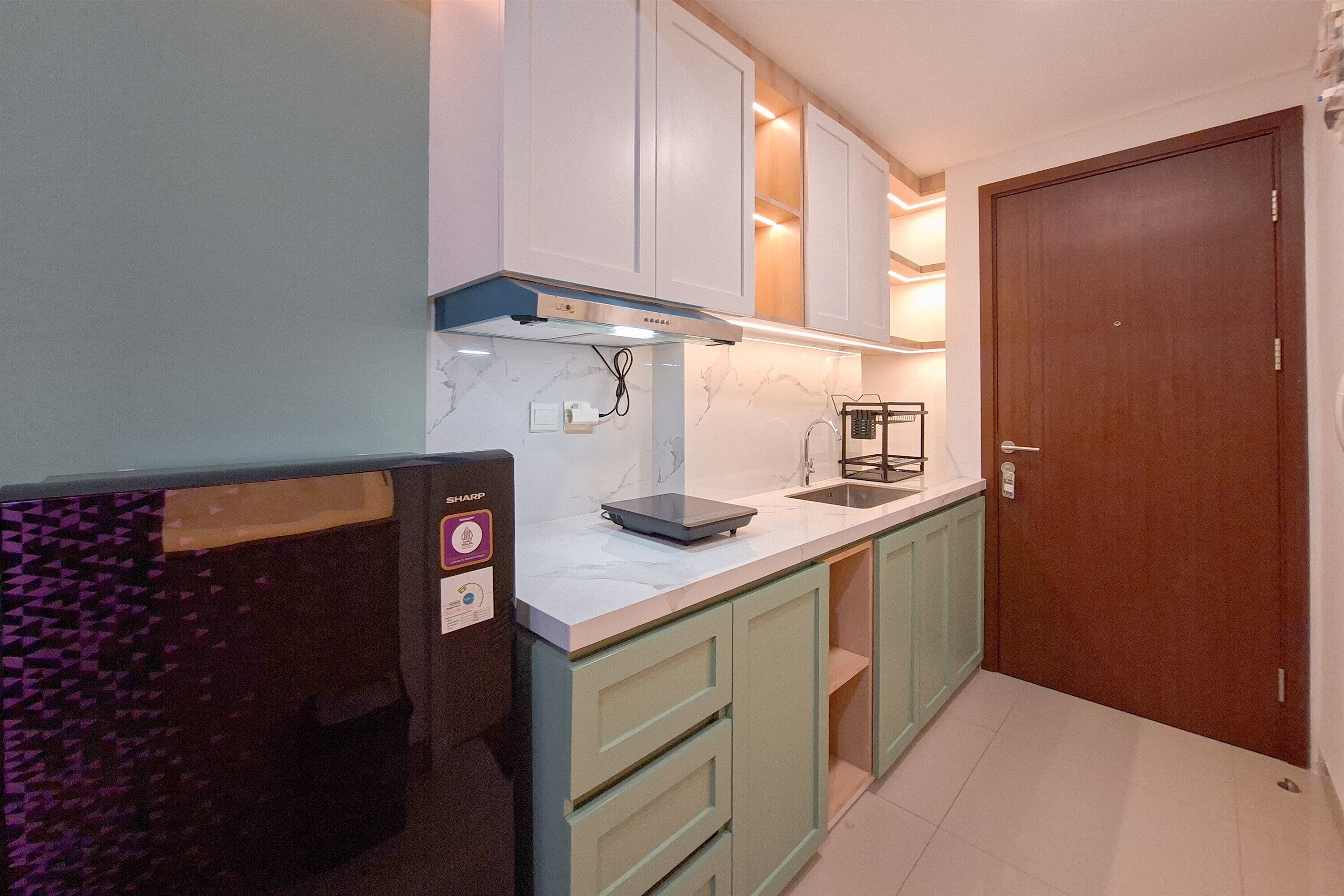 A kitchen with white cabinets, a marble backsplash, and a wooden door.