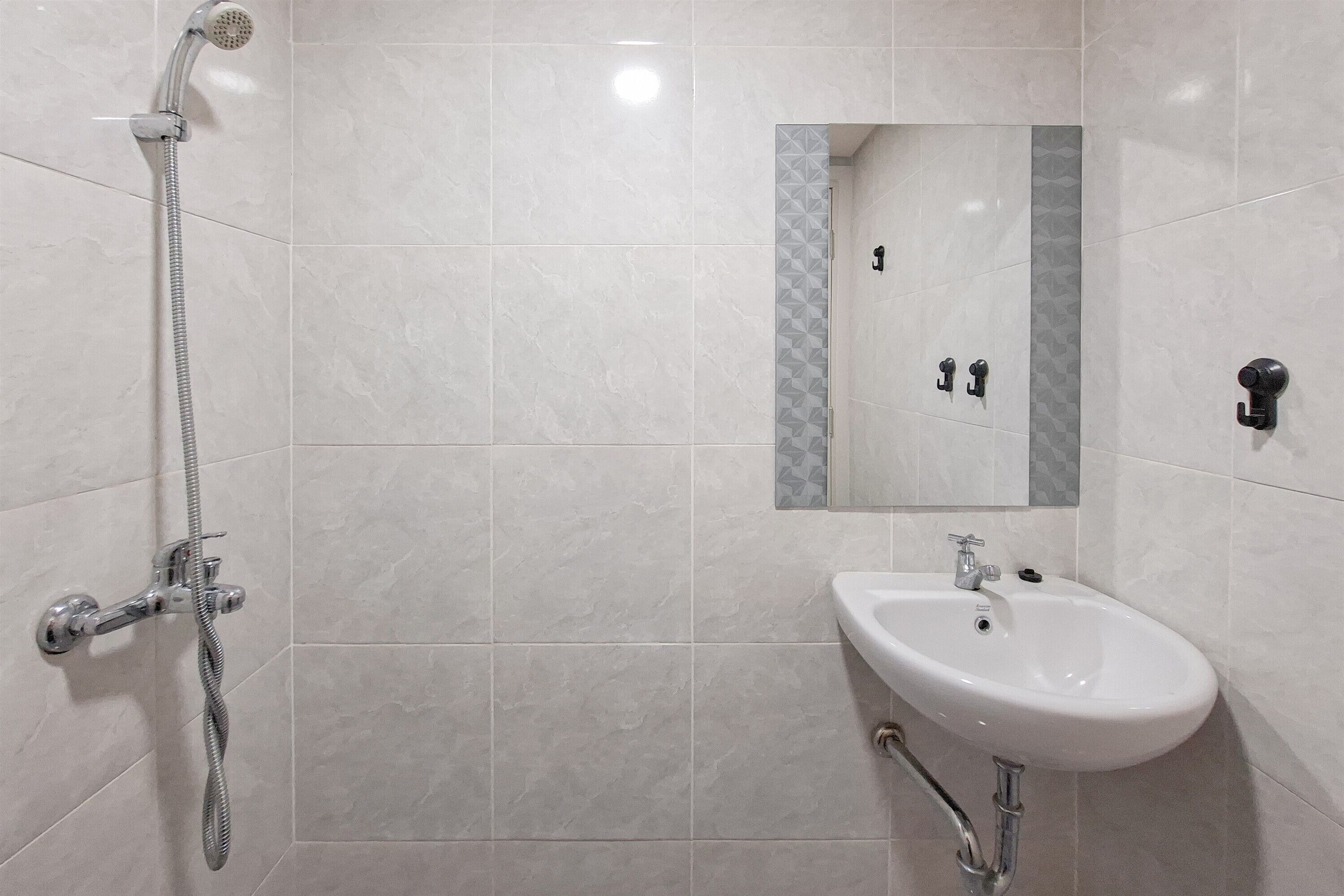 A bathroom with a shower, sink, and mirror.