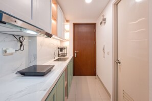 Standard Apartment | Private kitchen - Simple Neutral Toned Studio Room At Parkland Avenue Apartment (South Tangerang)