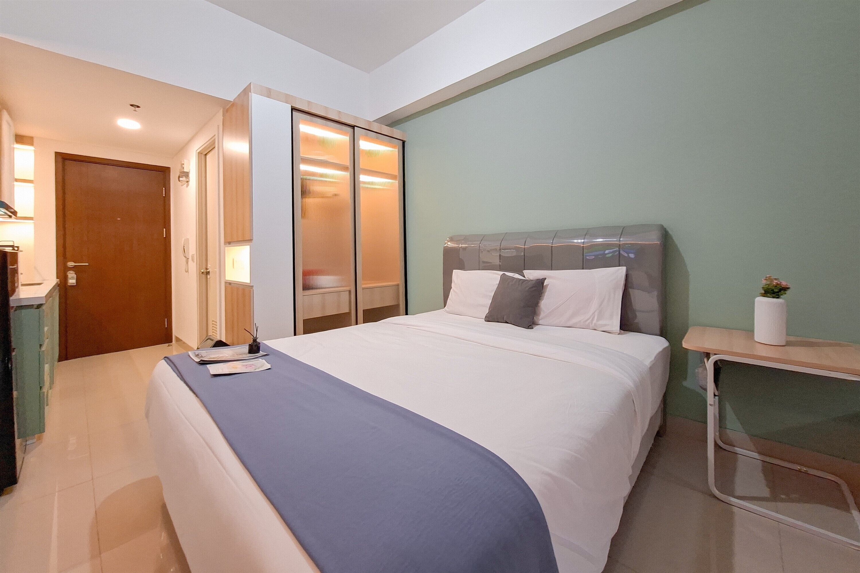 A bedroom with a bed, bedside table, and a wardrobe with sliding doors.