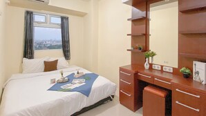 A hotel room with a bed, a desk with a mirror, and a window with curtains. - Combined 1Br With Extra Room Apartment At Green Pramuka City (Jakarta)