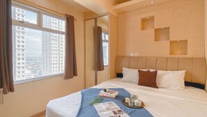 A hotel room with a large bed, a view of the city through the window, and a modern design. - 2Br Near Baywalk Mall Apartment At Green Bay Pluit (Jakarta)