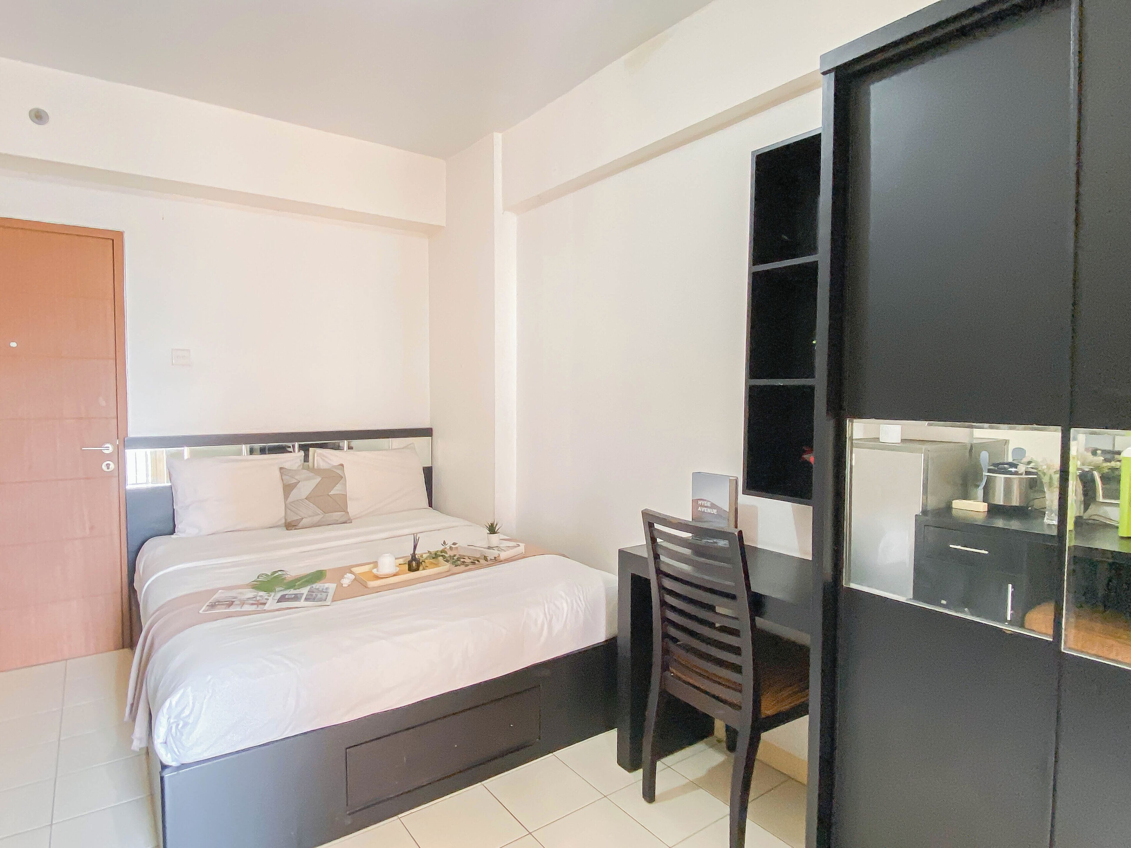 Ein modernes Schlafzimmer mit Bett, Schreibtisch und Kleiderschrank.