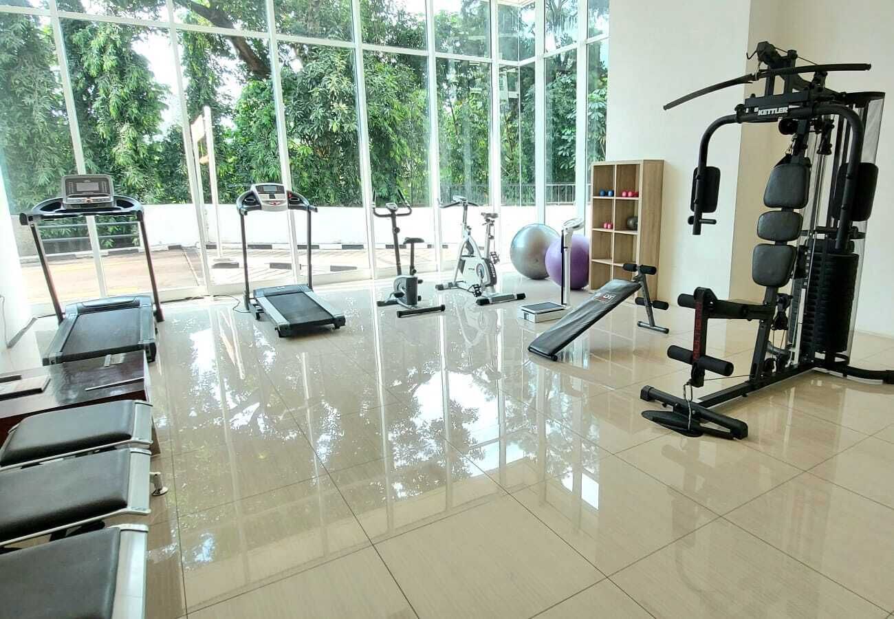 A gym with exercise equipment, a treadmill, and a weight machine.