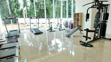 A gym with exercise equipment, a treadmill, and a weight machine.
