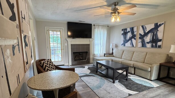 A living room with a fireplace, a sofa, a coffee table, and a TV. - Cozy 5BR / 2.5BA- Brick Home in Olive Branch (Olive Branch)
