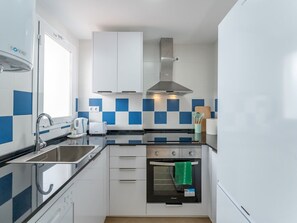 Frigorífico, lavavajillas, utensilios de cocina y mesa de comedor