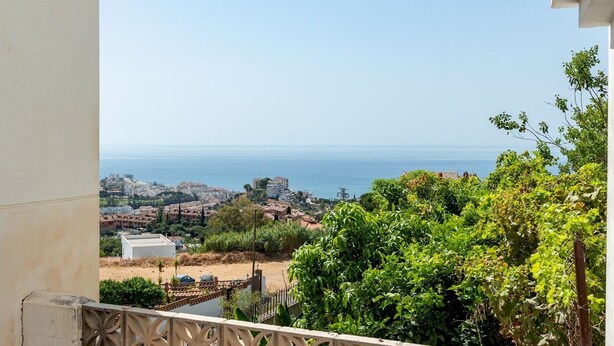 Un balcón con vistas a un pueblo costero y al mar.