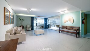 A spacious lobby with a sofa, bench, and a dining table. - 1 Bedroom Apart w/ Air 120m From the Beach Esb0310 (Salvador)