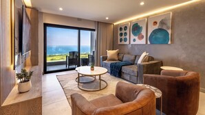 Una sala de estar moderna con un sofá, sillones, una mesa de centro y obras de arte en la pared.