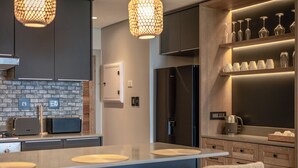 Una cocina moderna con salpicadero de ladrillo, electrodomésticos de acero inoxidable y una isla central con asientos.