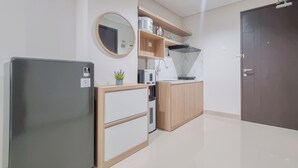 Una cocina moderna con refrigerador, microondas, tostadora y armarios de madera.