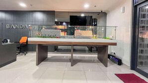 A modern office space with a large conference table, a reception area, and a decorative model cityscape. - Standard Studio (No Kitchen) At Bandaraya - Tallasa City Makassar Apartment (Makassar)