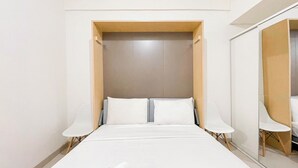 A modern hotel room with a large bed, two bedside tables, and a mirror on the wall. - Standard Studio (No Kitchen) At Bandaraya - Tallasa City Makassar Apartment (Makassar)