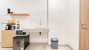 A compact kitchen with a microwave, kettle, and small refrigerator. - Simple Look Studio (No Kitchen) Near Unhas Bandaraya - Tallasa City Makassar Apartment (Makassar)