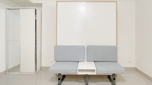 A room with a white wardrobe, a grey bench, and a white table. - Studio (No Kitchen) Apartment At Bandaraya - Tallasa City Makassar Near Unhas (Makassar)