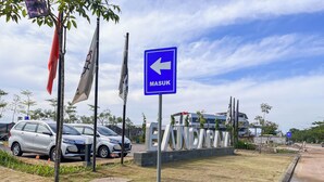 A parking area with cars and a blue directional sign indicating 'MASUK' (enter). - Neat Studio (No Kitchen) At Bandaraya - Tallasa City Makassar Apartment (Makassar)