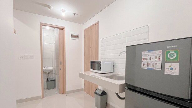 A modern kitchen with a microwave, refrigerator, and sink. - Minimalist 1Br Combined (No Kitchen) At Bandaraya - Tallasa City Makassar Apartment (Makassar)