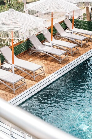 A poolside area with lounge chairs and white umbrellas. - Vila Malo (Ksamil)