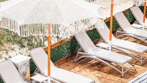 A poolside area with lounge chairs and white crocheted umbrellas. - Vila Malo (Ksamil)