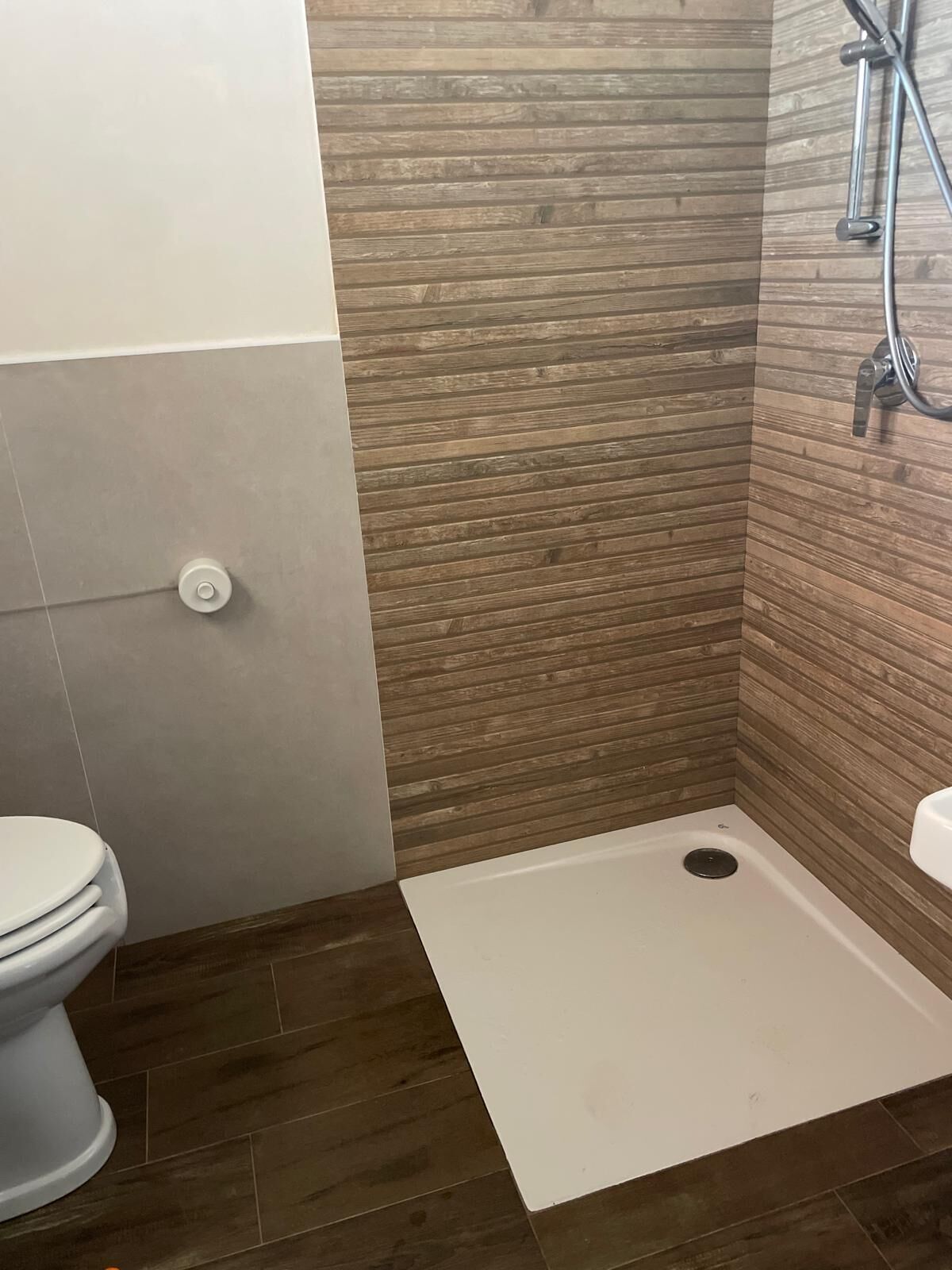 A bathroom with a shower, toilet, and sink.