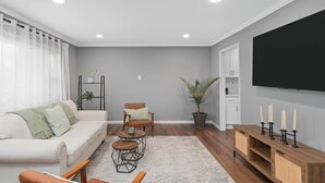 A living room with a sofa, chairs, a coffee table, a TV, and a fireplace. - Cozy Home, 17 min from NYC, 2 Parking Spaces (Ridgefield Park)