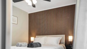 A hotel room with a bed, a ceiling fan, and two wall-mounted lamps. - Cozy Pool House 24 min to Beach, Cozy Pool House 24 min to Beach (Manatee County)