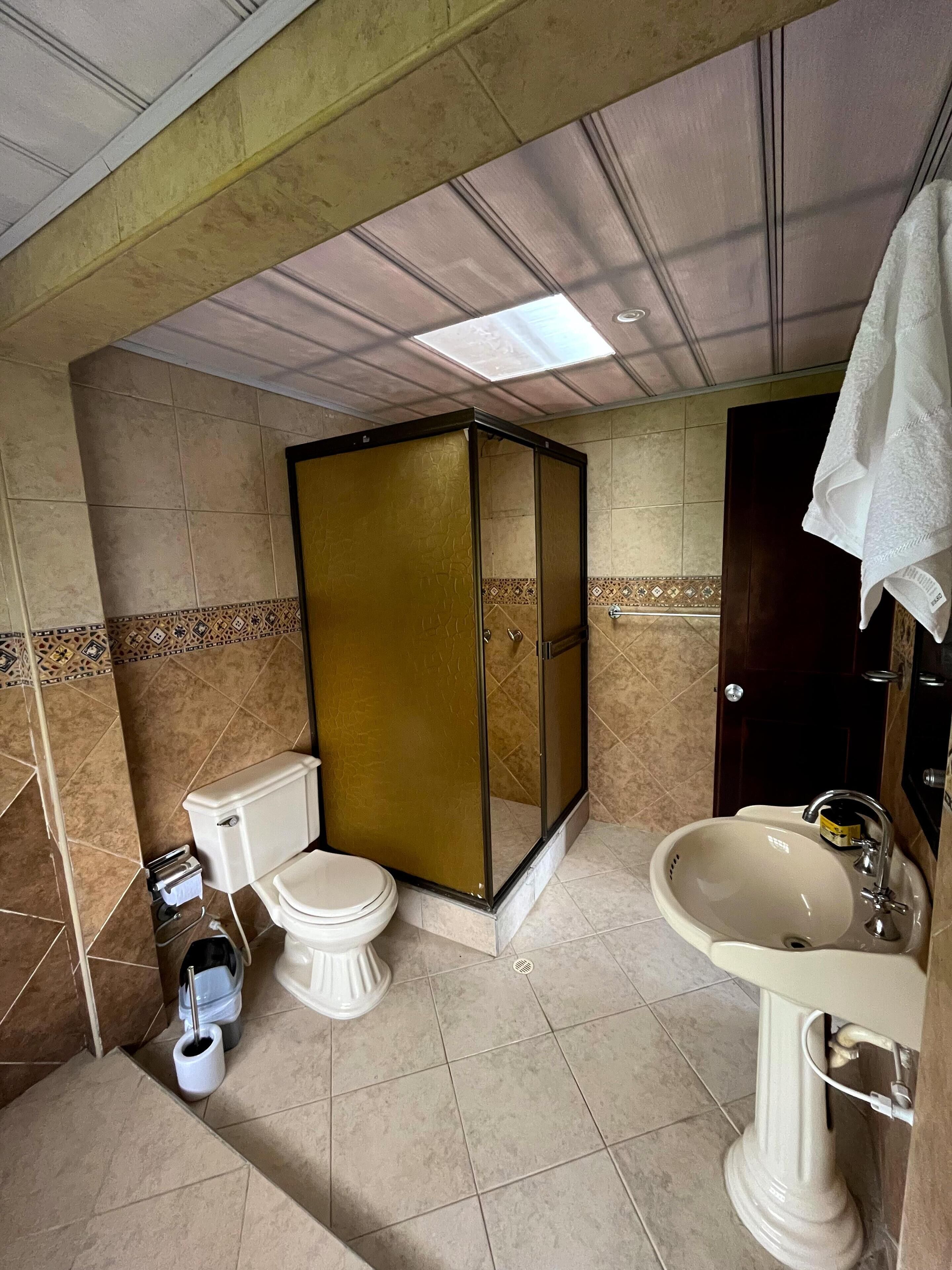 Ein Badezimmer mit Toilette, Bidet, Dusche und Waschbecken.