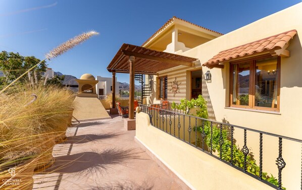 A residential property with a covered patio, a small garden, and a mountain view.