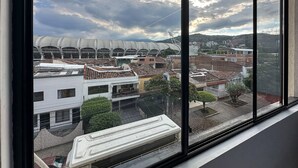 Blick aus einem Fenster auf eine Stadtlandschaft mit einem Stadion und Wohngebäuden.