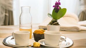A tray with two cups of tea, a glass of water, a muffin, and a small plant on a table. - Rome Point Inn (Rome)