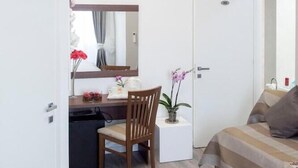 A modern bedroom with a bed, a desk, and a chair. - Rome Point Inn (Rome)