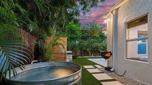 Un área de spa con jacuzzi, césped artificial y valla de madera.