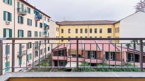 A multi-story building with balconies and a red-roofed structure in the center. - Cozy apartment in Bovisa (Milano)