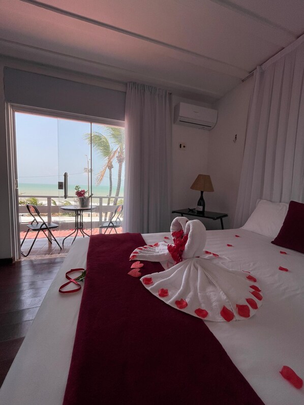 Ein Hotelzimmer mit Bett, Tisch und Stuhl neben einer Glastür.