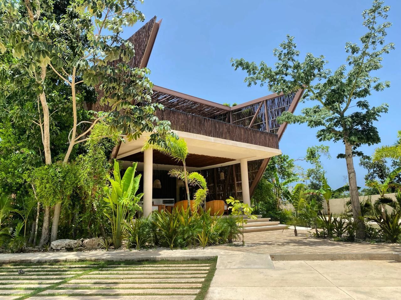 A modern building with a sloped roof and a covered outdoor area.