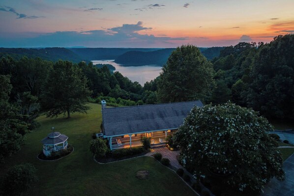 A house with a large lawn, a gazebo, and a view of a lake at sunset. - Waterfront Fox Hill Cabin - Rustic Retreat w/ Fire Pit (Baxter)