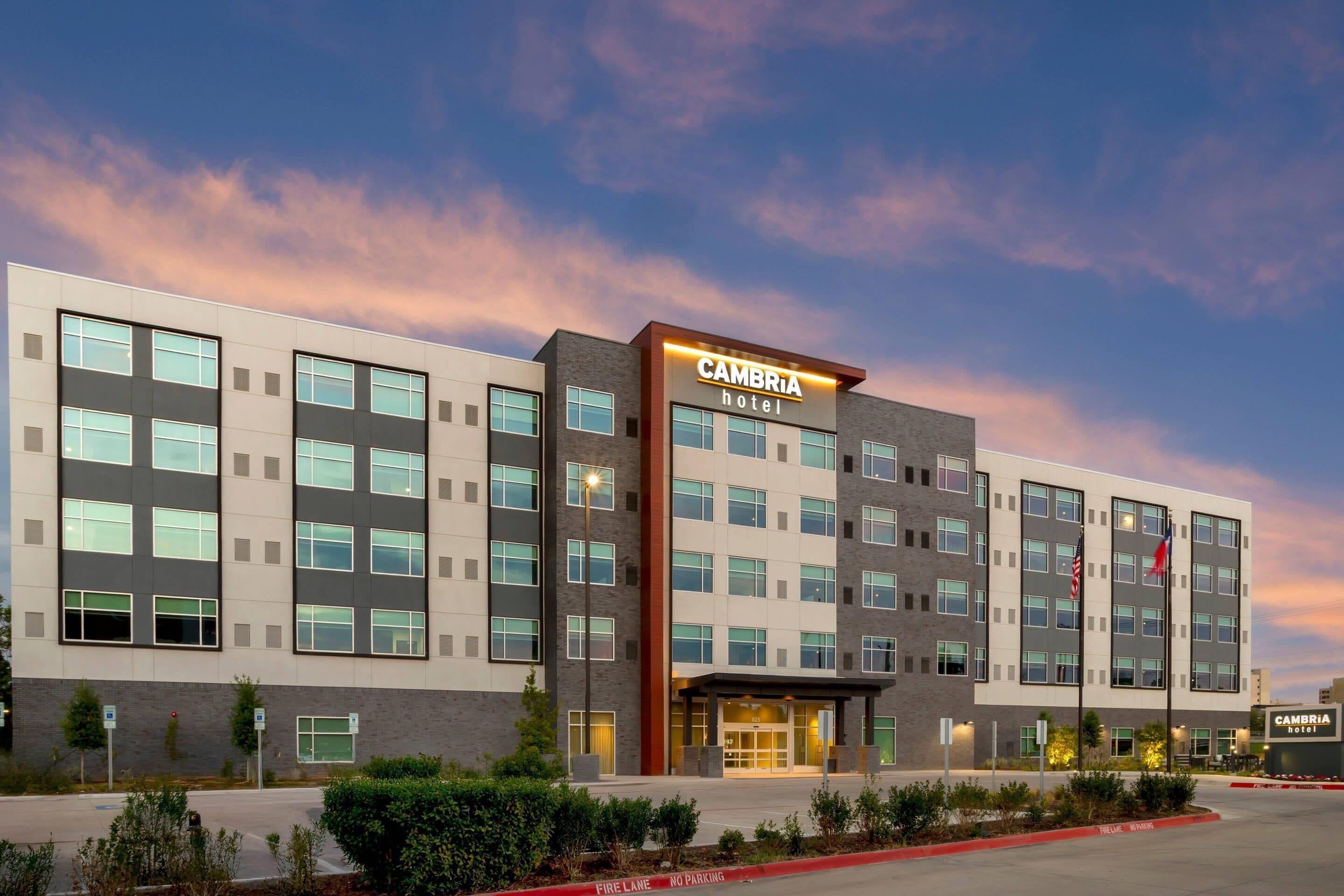 A modern hotel building with a flat facade, multiple windows, and a prominent entrance.