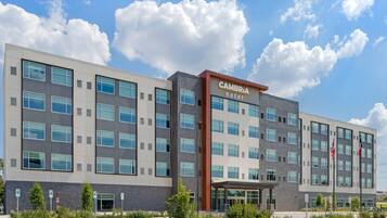 A modern hotel building with multiple floors, large windows, and a prominent entrance.