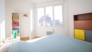 A bedroom with a bed, a window, a wardrobe, and a radiator. - LES LOGIS DU GENERAL - Ground floor apartment (Beaupréau-en-Mauges)