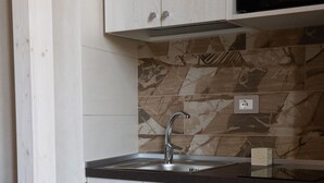Een moderne keuken met een ingebouwde gootsteen, een magnetron en een eethoek met een tafel gedekt voor twee personen.