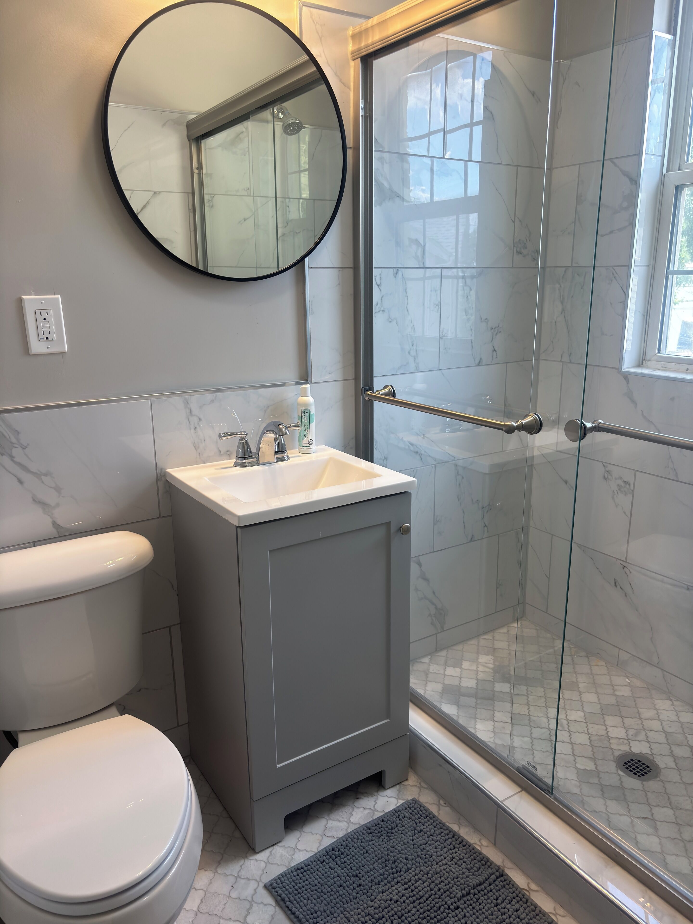 Een badkamer met toilet, wastafel en douche.