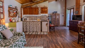 A cozy kitchen with wooden cabinets, a central island, and a dining area with a wooden table and chairs.