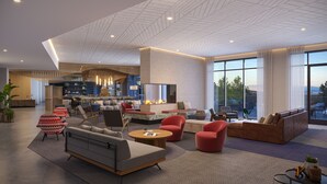 Un vaste espace de vie doté d’une cheminée, de sièges confortables et de grandes fenêtres offrant une vue sur l’extérieur.